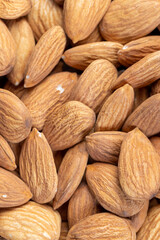 a lot of almond nuts on the table, ready-to-eat almond nuts on a wooden table, close up