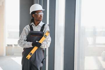 Construction worker holding level tool inspecting building site