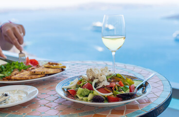 Greek salad and wine in Greece in a restaurant. Selective focus.