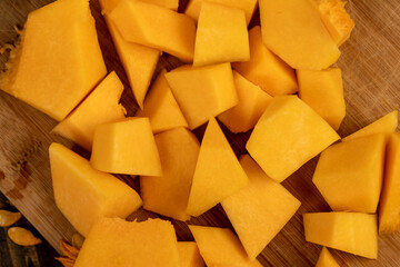 cut one pumpkin in the kitchen close up, preparation of ripe yellow pumpkin for baking and cooking other food