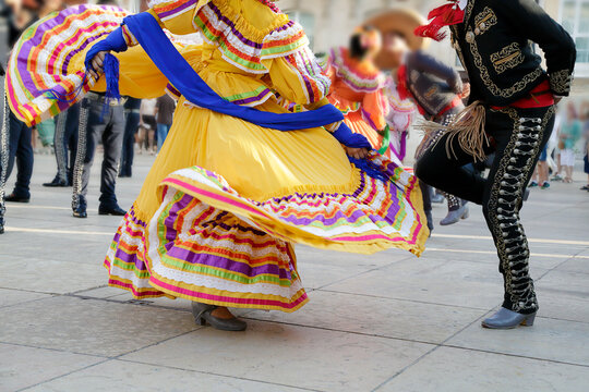 Dancers dancing and wearing one of the traditional folk costume from Mexico