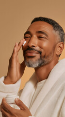 Mixed race man wearing a bathrobe gently applies face cream, enjoying his morning skincare routine with a smile, promoting healthy skin and self-care, male skin care routine 