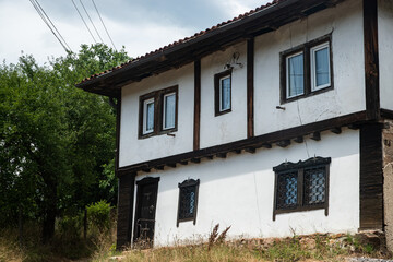 Traditional Balkan village house with white walls and dark wooden beams