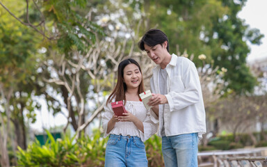 Asian Couple Exchanging Gifts Outdoors