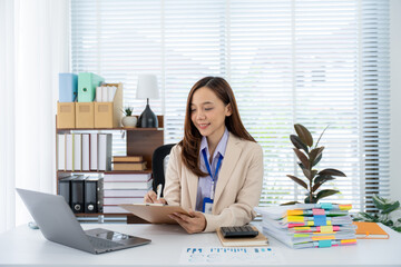 Focused Professional at Work: A dedicated professional sits at her desk, absorbed in her tasks. A...