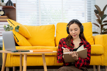 Focused Reflection: A woman engrossed in thoughtful reflection, diligently writing notes in a...