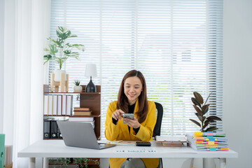 Office Workspace: A modern office setting features an woman smiling while using her phone on a...