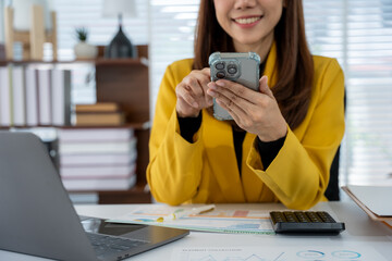 Businesswoman working on the smartphone: A bright and optimistic businesswoman, immersed in her...