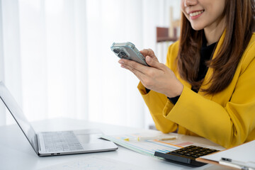 Modern Office: A focused individual engaged in mobile device use, complemented by a laptop,...