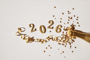 New Year 2026 festive background with golden champagne bottle, party streamers, confetti stars and glittering numbers.