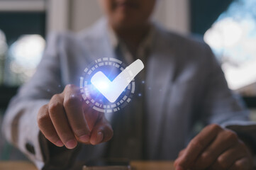 Close-up of businessman tapping digital check mark icon on virtual interface, symbolizing approval, confirmation, validation, success, or digital agreement in modern business technology.