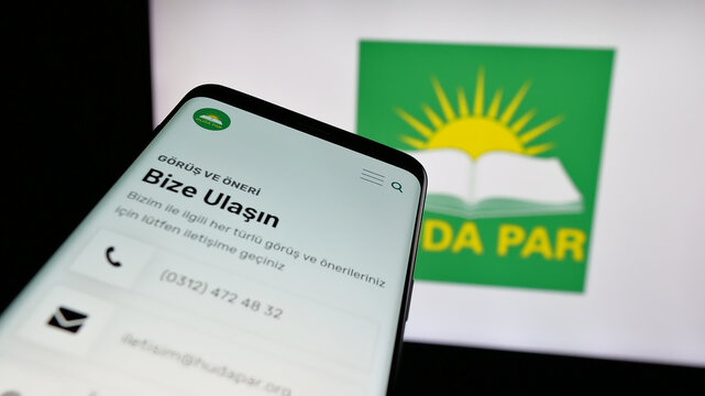Stuttgart, Germany - 07‑23‑2025: Mobile phone with website of Turkish party H&uuml;r Dava Partisi (H&uuml;da Par) on screen in front of logo. Focus on top-left of phone display.