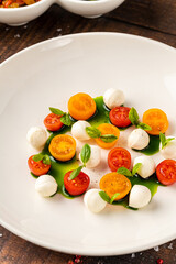 Colorful Caprese salad with cherry tomatoes, mozzarella and fresh basil