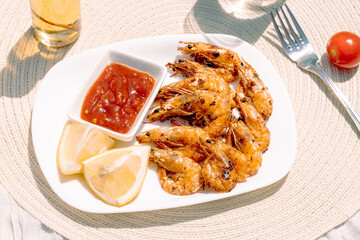 Low-calorie grilled shrimp with lemon, garlic, and butter, served with fresh parsley and tangy cocktail sauce, a perfect healthy seafood choice for clean eating.