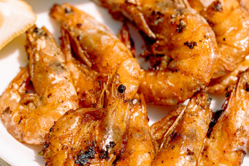 Grilled shrimp in garlic lemon butter sauce, served with lemon wedges and spicy seafood sauce, a light and healthy high-protein dish.