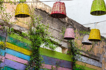 Colorful handmade basket lamps and painted wooden fence in artistic outdoor cafe in Old Bar, Montenegro