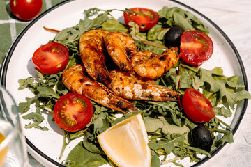 A warm summer salad of king prawns, rucola, lemon and cherry tomatoes — Mediterranean simplicity on a plate.