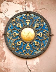 Ornate circular metal emblem on weathered wall