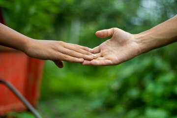 The younger brother is letting go of the older brother's hand emotionally, and the background behind them is blurred.