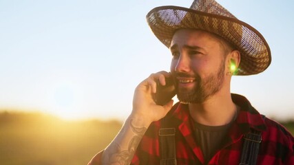 Happy farmer walking and talking by mobile phone in farmland, male portrait. Good mood and positivity, using mobile net in countryside, business negotiation, carefree countryman enjoying simple life
