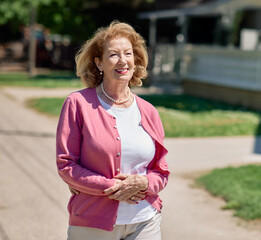 Portrait of a happy senior elderly woman standing walking and relaxing outdoors