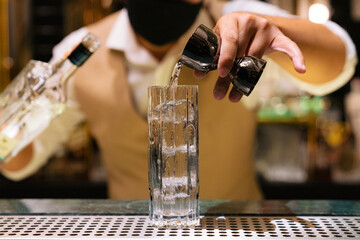 Bartender Pouring Alcohol into a Glass with Ice