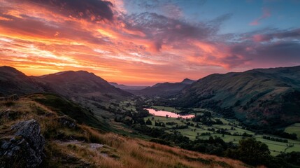 Fototapeta premium Orange and Pink Sunset Over a Valley Between Hills and Lake