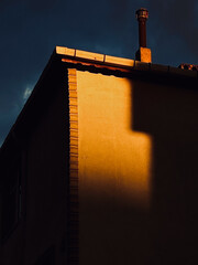 Abstract View of a Building Corner and Chimney Lit by Warm Sunset Light