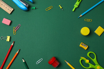 School supplies frame on green background. Back to school concept.