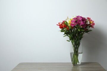 Colorful alstroemeria flowers in glass vase on the table