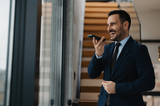 Portrait of handsome well dressed businessman using phone