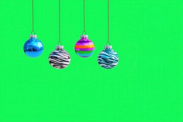 Colorful Christmas ornaments on bright green background