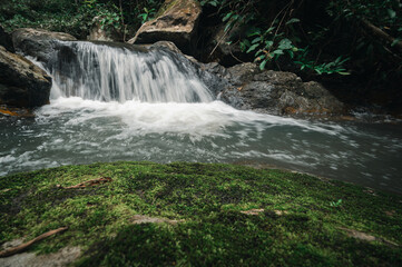 Serene Waterfall Flowing Over Rocks in Lush Green Landscape