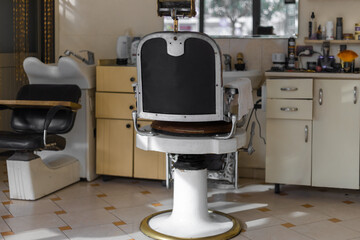 Stylish vintage barber shop. Professional hairstylist in barbershop interior with armchair.