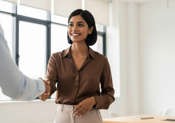 Smiling Businesswoman Shaking Hands in Modern Office Setting
