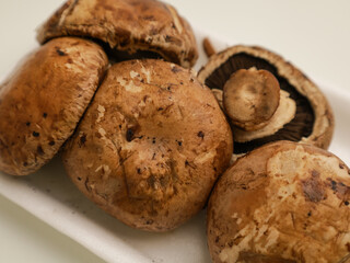 Portobello mushrooms on Styrofoam tray, isolated on white background
