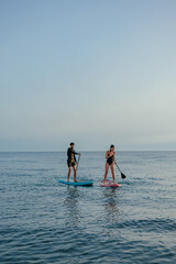 Naklejka premium Two people paddling on paddleboards