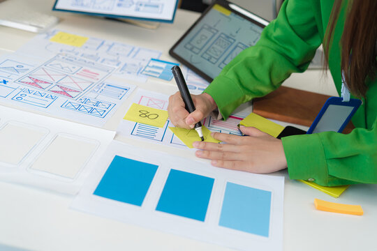 Creative digital development agency. developer team brainstorming on their project with laptop, smartphone and digital tablet.