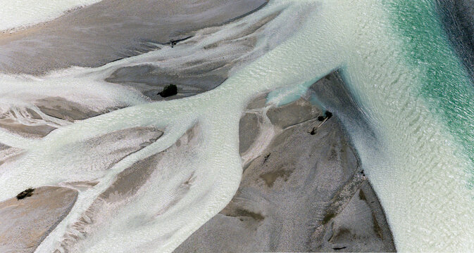 Iconic Italian river Tagliamento, Friuli, Carnia, Italy. Aerial view of the braided riverbed with pale water flowing through gravel banks.