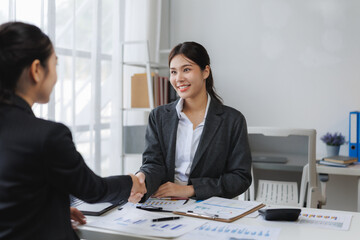 Businesswomen shaking hands after successful meeting in office