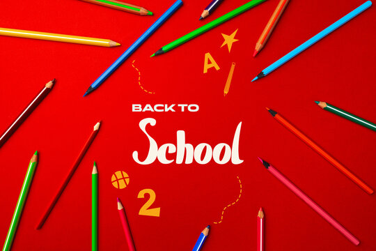Colorful school supplies arranged around a vibrant back to school message on a bright red background - Powered by Adobe
