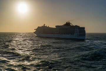 Obraz premium Luxury cruise ship goes into horizon at sunset