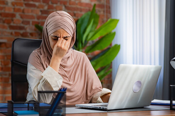 Stressed Woman in Hijab Working at Her Office Desk