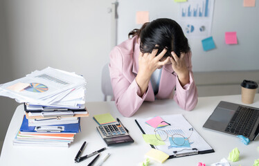 Working Asian women feel stressed, tired from work, migraine headaches from hard work while working...