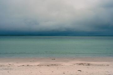 Deep turqoise waters under dark blue clouds
