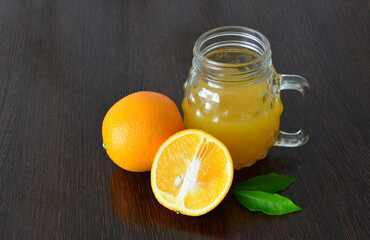 Fresh Orange Juice and Oranges on a Dark Wood Surface copy space