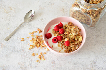 pink bowl with Granola, yogurt and Raspberries flat lay still life