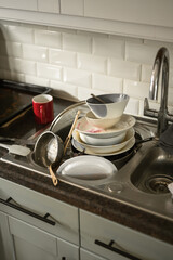 Dirty dishes in kitchen's sink, daily chores, cleaning home 
