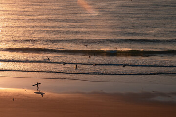 Silhouettes and shadows of early morning surfers at first light at Yamba Main Beach