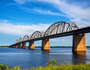 Fototapeta premium Steel bridge spanning a wide river under a partly cloudy sky